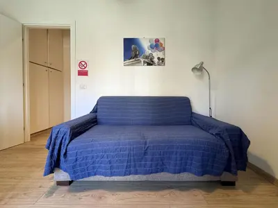 a bed in a room with a blue blanket on it at JHHIT Tuscolana Suite 01 with Terrace in Rome