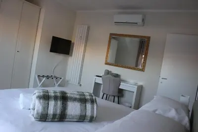 a bedroom with a bed with a desk and a mirror at New Green Hill Apartment - Colli Portuensi in Rome