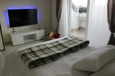 a blanket laying on a bed in a room with a television at New Green Hill Apartment - Colli Portuensi in Rome