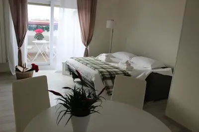 a hotel room with a bed and two tables at New Green Hill Apartment - Colli Portuensi in Rome