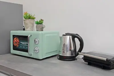 a green microwave and a tea kettle on a counter at 4BNB - Baldo degli Ubaldi Big Apartment in Rome