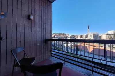 a chair on a balcony with a view of a city at 4BNB - Baldo degli Ubaldi Big Apartment in Rome