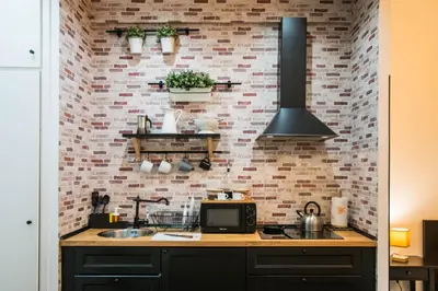 a kitchen with a sink and a brick wall at St. Peter Sweets in Rome