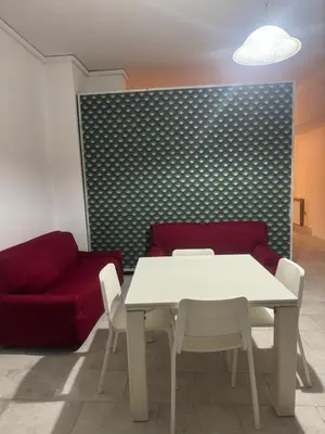 a living room with a white table and a red couch at Munsi guest house in Rome