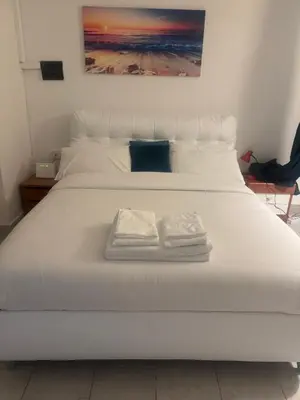 a large white bed with two towels on it at Munsi guest house in Rome