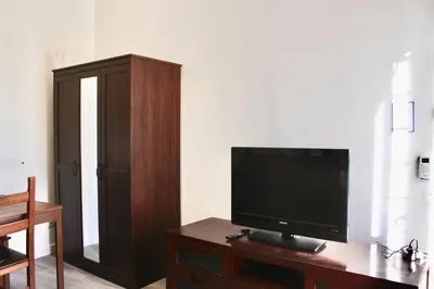 a living room with a television on a wooden table at HC - Richetta's Comfy House near the Vatican in Rome
