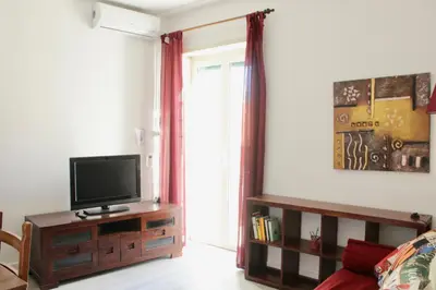 a living room with a flat screen tv on a wooden cabinet at HC - Richetta's Comfy House near the Vatican in Rome