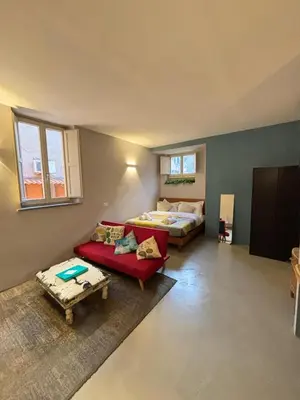 a living room with a bed and a red couch at La casa di zoe in Rome