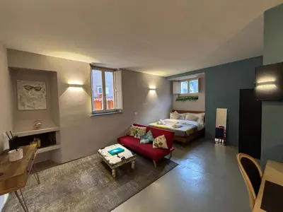 a living room with a bed and a red couch at La casa di zoe in Rome