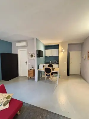 a living room with a table and a kitchen at La casa di zoe in Rome