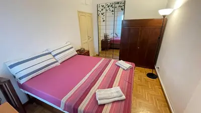 a bedroom with a bed with pink sheets and two towels at Da Naya all' Appia Antica in Rome