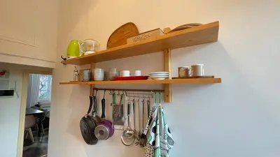 a kitchen with wooden shelves on the wall with utensils at Da Naya all' Appia Antica in Rome