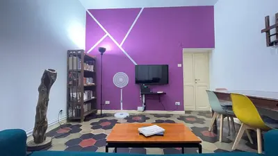 a living room with a purple wall and a table and chairs at Da Naya all' Appia Antica in Rome