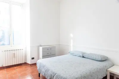 a white bedroom with a bed and a window at Domus Magnagrecia in Rome