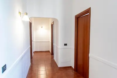a hallway with white walls and a wooden door at Domus Magnagrecia in Rome
