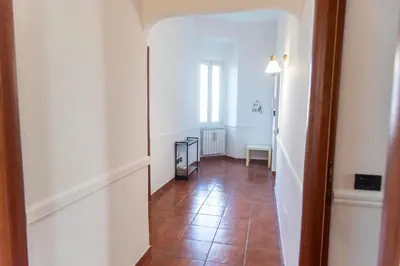 a hallway with a tile floor and white walls at Domus Magnagrecia in Rome
