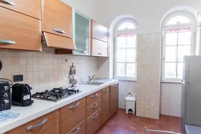 a kitchen with wooden cabinets and a stove top oven at Domus Magnagrecia in Rome