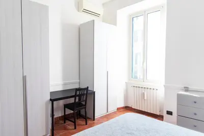 a bedroom with a desk and a window at Domus Magnagrecia in Rome