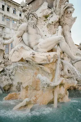 a statue of a man sitting on top of a fountain at Bijoux de Rome Navona Luxury Apartment in Rome