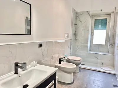 a white bathroom with a toilet and a sink at Xcross Suites Garbatella in Garbatella