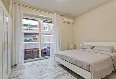 a bedroom with a bed and a large window at Vatican's Apartment in Rome