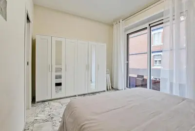 a bedroom with a bed and a large window at Vatican's Apartment in Rome