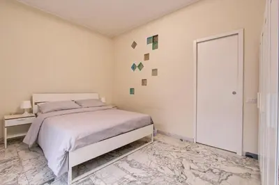 a white bedroom with a bed and a door at Vatican's Apartment in Rome