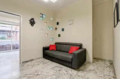 a leather couch in a living room with pictures on the wall at Vatican's Apartment in Rome