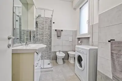a bathroom with a sink and a washing machine at Vatican's Apartment in Rome