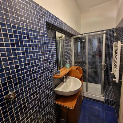 a blue tiled bathroom with a sink and a shower at vacanze romane in Rome