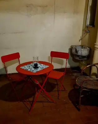 a red table and two chairs in a room at vacanze romane in Rome