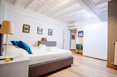 a bedroom with a large bed with blue pillows at Elegantis Monti Suite Apartment in Rome