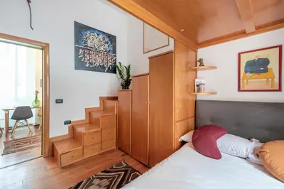 a small bedroom with a bed and a staircase at Bright Loft Rome City Center in Rome