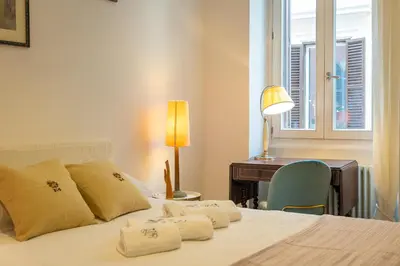 a bedroom with a bed with a desk and a window at Secret Terrace by Rental in Rome in Rome