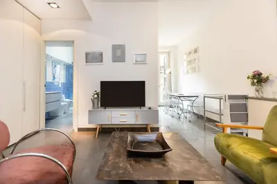 a living room with a tv and a couch and a table at Secret Terrace by Rental in Rome in Rome