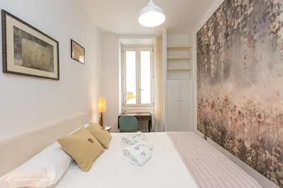 a bedroom with a bed with a large painting on the wall at Secret Terrace by Rental in Rome in Rome