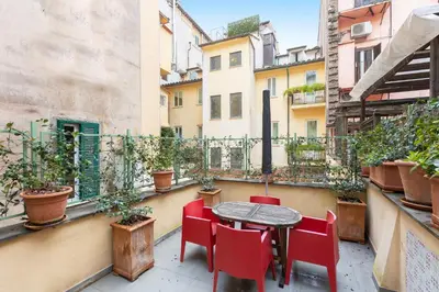 a small table and chairs on a balcony with plants at Secret Terrace by Rental in Rome in Rome