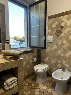 a bathroom with a toilet and a sink and a window at CardinalBaldo in Rome