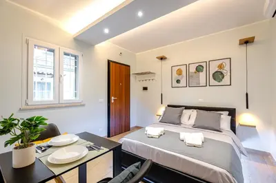 a bedroom with a bed and a table with chairs at Suite Room Suriani in Rome