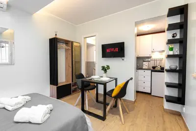a room with a bed and a table and a kitchen at Suite Room Suriani in Rome