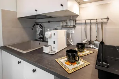 a kitchen counter with a coffee maker and two cups at Suite Room Suriani in Rome