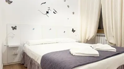 a bedroom with two beds and a window with butterflies on the wall at Casa Roma in Rome