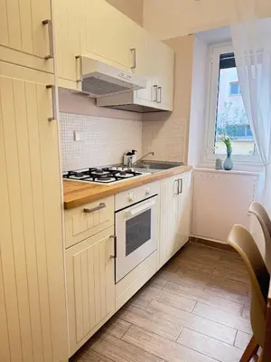 a kitchen with white cabinets and a stove top oven at Vatican Exclusive Suite in Rome