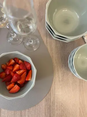 a bowl of strawberries on a table with wine glasses at Vatican Exclusive Suite in Rome