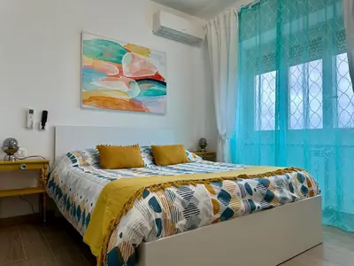 a bedroom with a bed with blue curtains at Monti Tiburtini Roma Guest House in Rome
