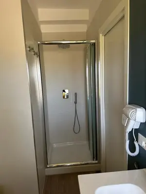 a shower in a bathroom with a phone on the wall at Monti Tiburtini Roma Guest House in Rome