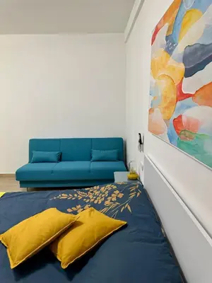a bedroom with a blue bed and a painting at Monti Tiburtini Roma Guest House in Rome