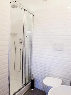 a white bathroom with a shower and a toilet at Spacious, Modern, Bright Apartment, near Piazza Navona! in Rome