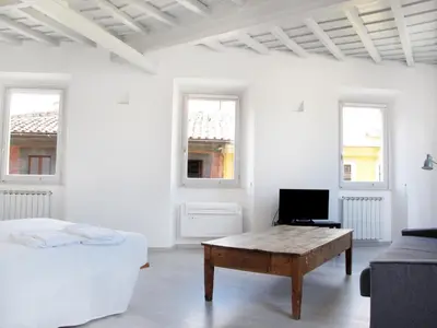 a white room with a bed and a coffee table at Spacious, Modern, Bright Apartment, near Piazza Navona! in Rome