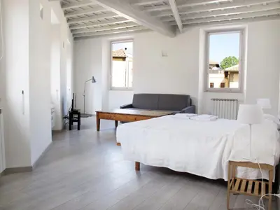 a white bedroom with a bed and a desk at Spacious, Modern, Bright Apartment, near Piazza Navona! in Rome